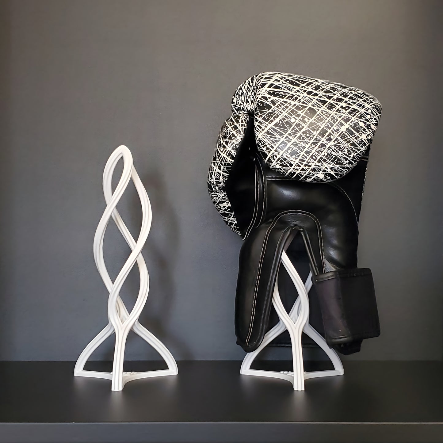 Das Bild zeigt zweimal den Nertas Boxhandschuh Trockner in weiß. Rechts mit schwarz weißem Handschuh